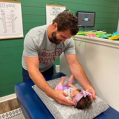 Chiropractor Suwanee GA Josh Hasty Adjusting Infant